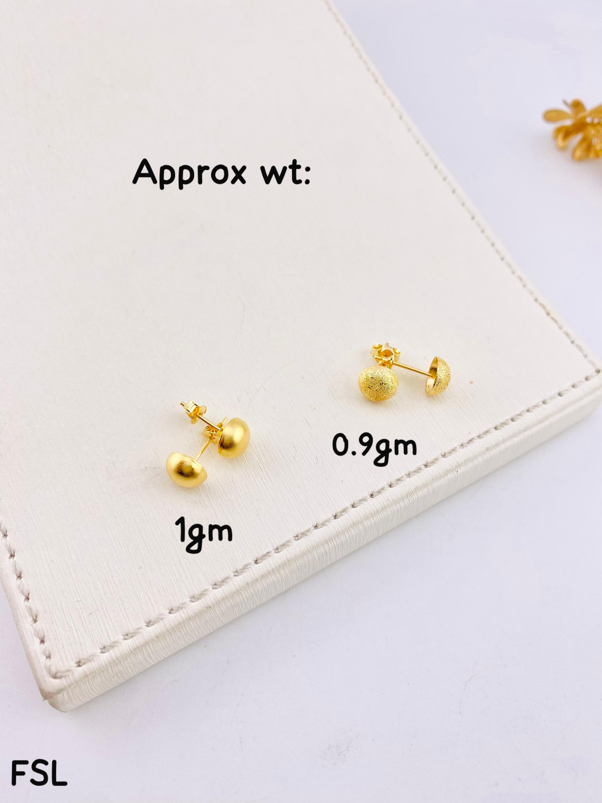 Gold earrings on a white card with weight labels