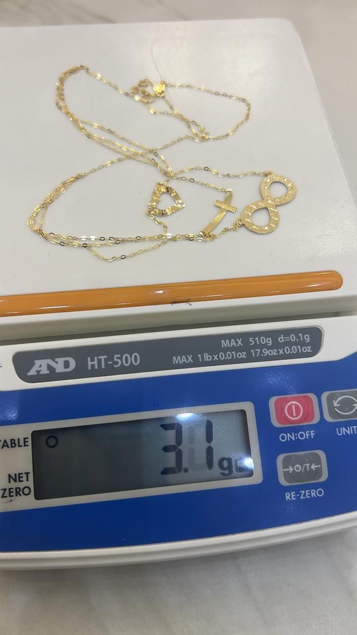 Gold necklace with 'LOVE' pendant on a digital scale displaying weight