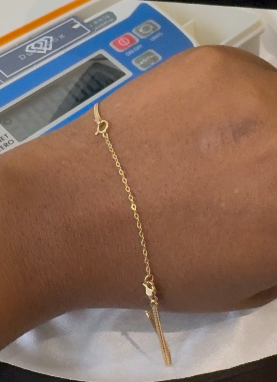 Gold bracelet on a wrist with a digital scale in the background